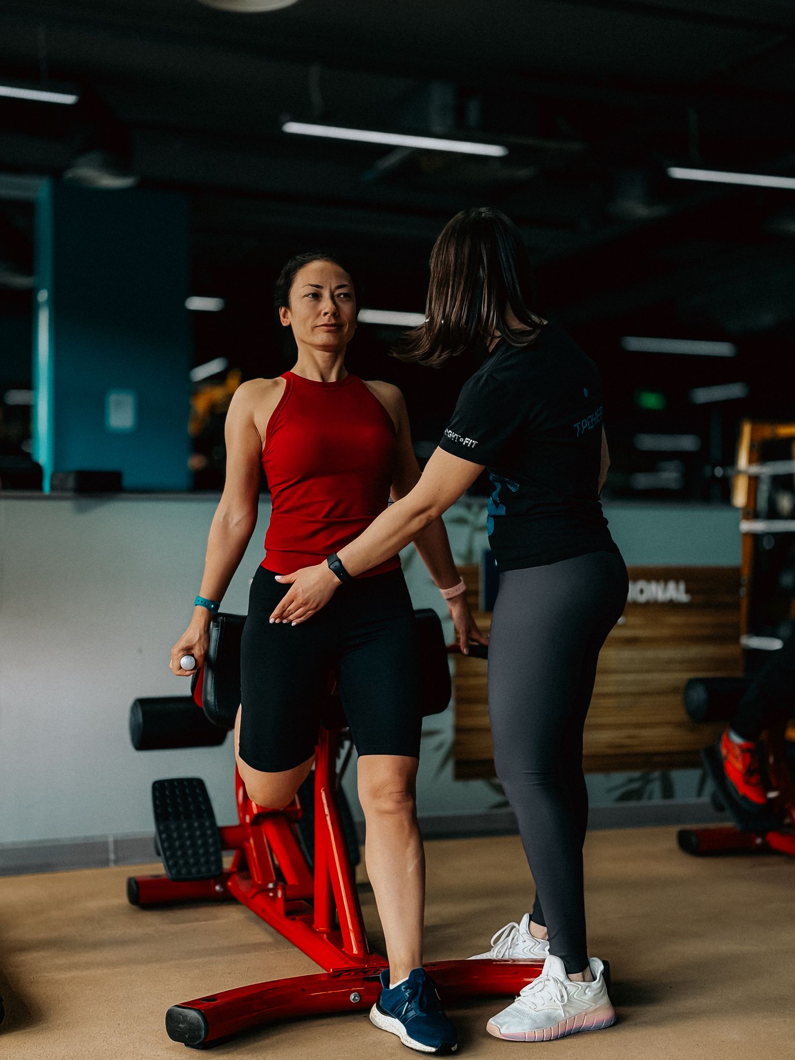 Personal trainer acompanhando de perto a execução do exercício — o mesmo cuidado recorrente que atendemos em outros nichos