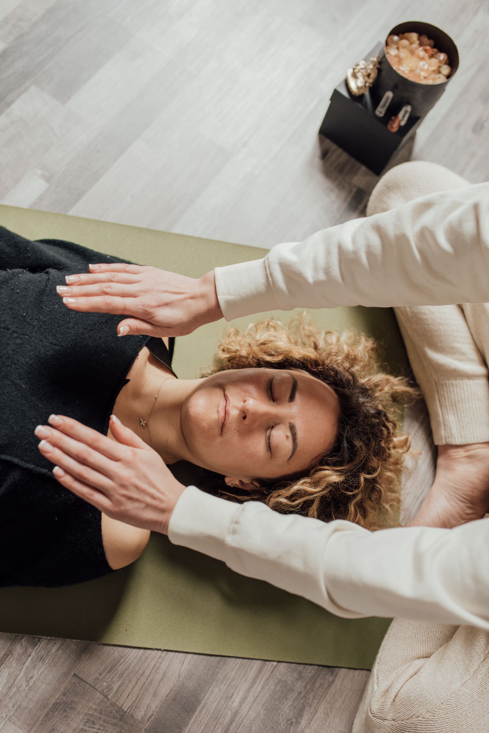 Sessão de reiki — mãos sobre a cliente, um dos nichos de cuidado recorrente que a eloo.digital atende